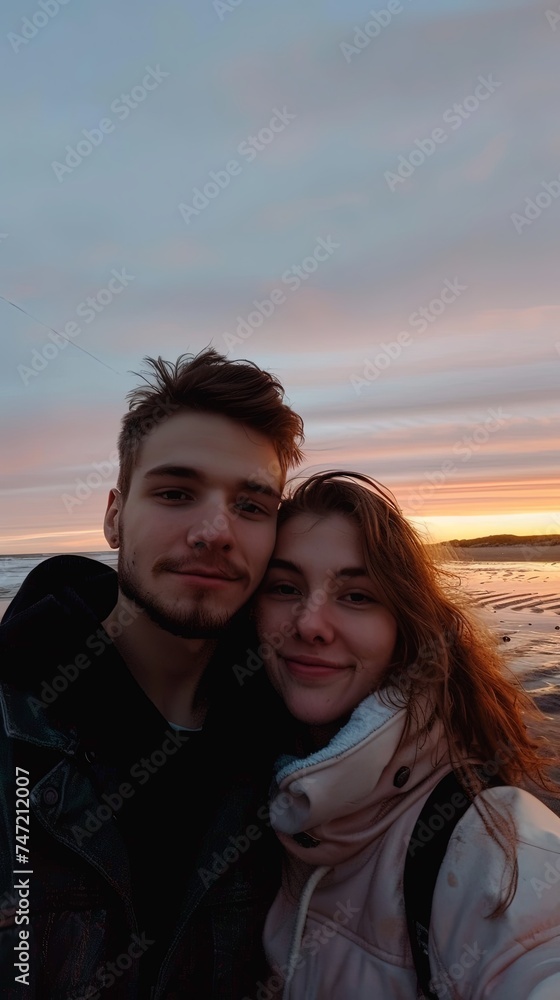 Teenagers couple vertical portrait standing on a beach