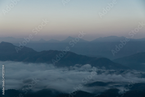Misty mountain landscape, clear blue cloudless sky and layers of hills. Cold mood. © InfoSoul