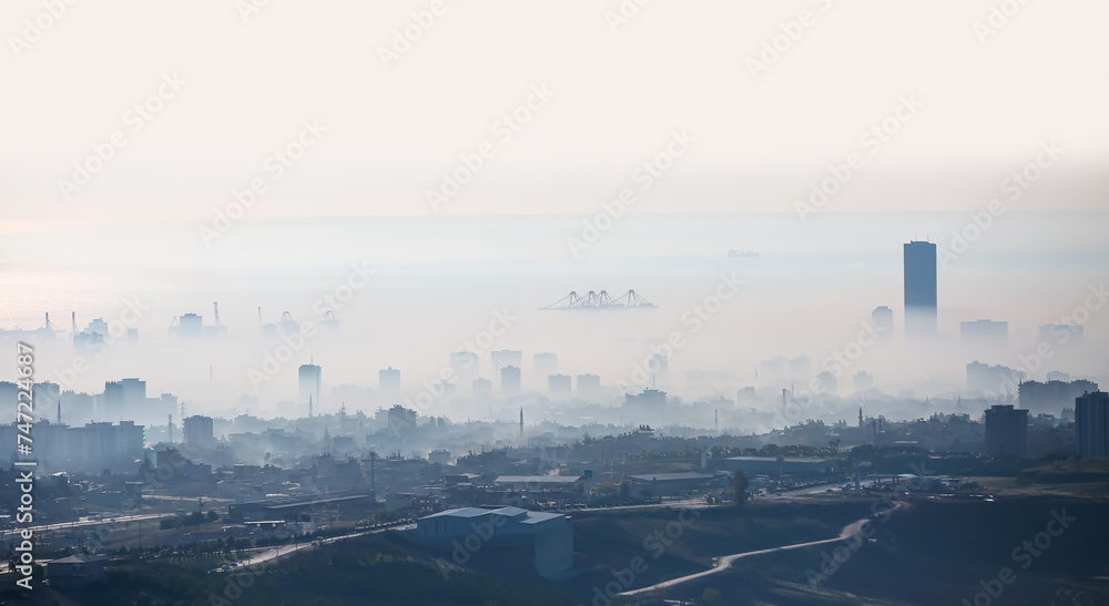 Cityscape of Mersin Downtown skyline on a foggy winter day - Aerial view of buildings and mersin port at a big city of Mersin, Turkey Cityscape of Mersin Downtown skyline on a foggy winter day - Aerial view of buildings and mersin port at a big city of Mersin, Turkey