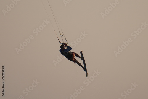Kiter jumps high above the water at sunset on Patara beach in Turkey