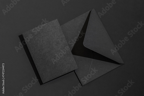 A black envelope on a black background with a blank black letterhead. photo