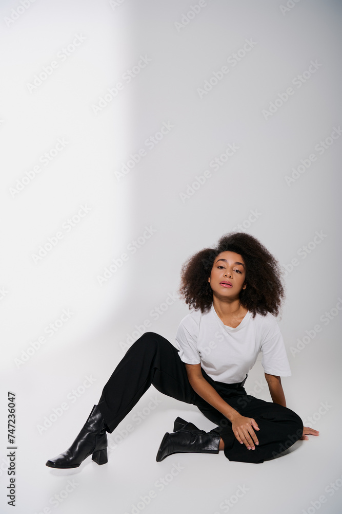 good looking african american female model sitting on floor and looking at camera, fashion concept good looking african american female model sitting on floor and looking at camera, fashion concept