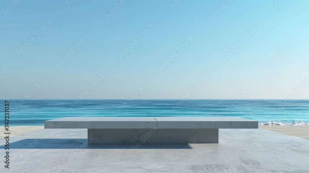 A minimalist concrete bench overlooks a tranquil and vast blue ocean under a clear sky. A minimalist concrete bench overlooks a tranquil and vast blue ocean under a clear sky.