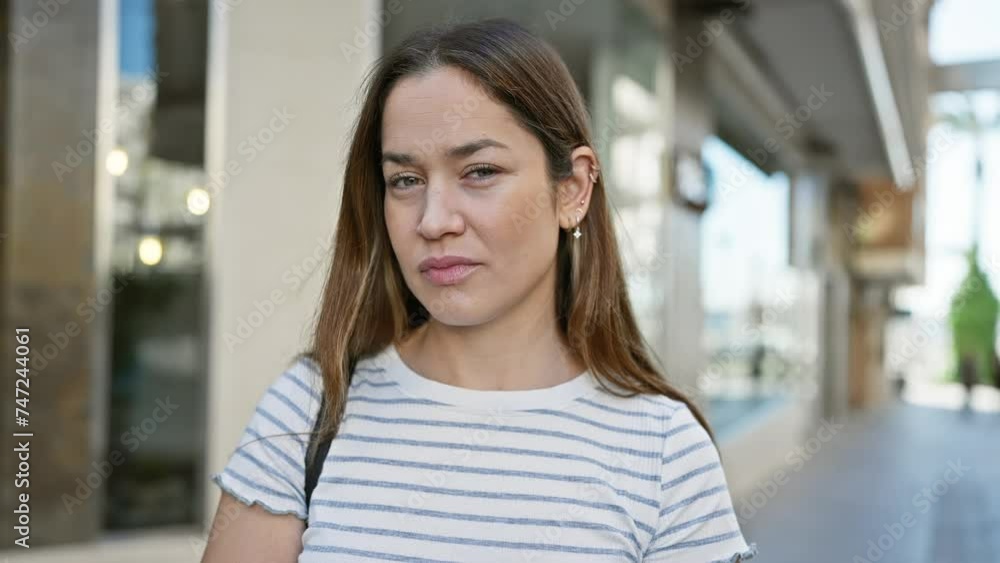Portrait of contemplative brunette woman with blue eyes on urban street Portrait of contemplative brunette woman with blue eyes on urban street