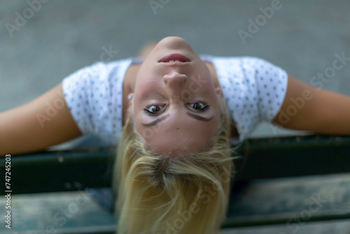 Female laying down with head tilted backward, hair flowing upside down