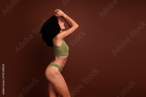 Studio no retouch profile photo of seductive lady dressed lingerie enjoying herself empty space isolated brown color background