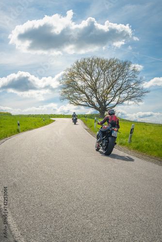 Bikers on the winding country road in spring