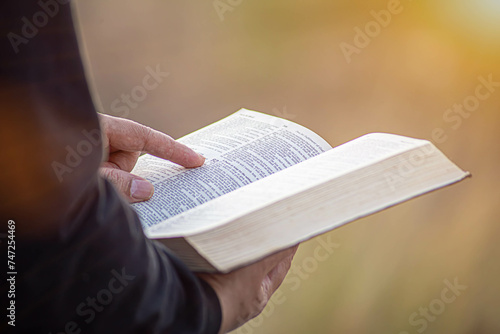 young man pointing to a bible topic and read the Bible on Sundays to receive the blessings of God. photo