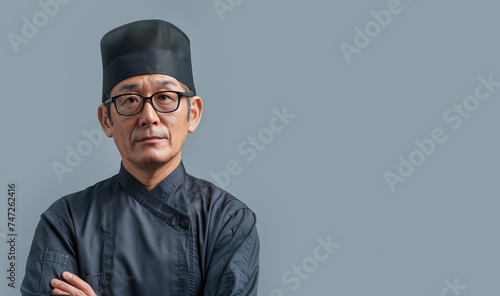 Portrait of a Asian chef on a gray background. Concept of Japanese, Chinese, Korean, Thai cuisine, gastronomy, kitchen