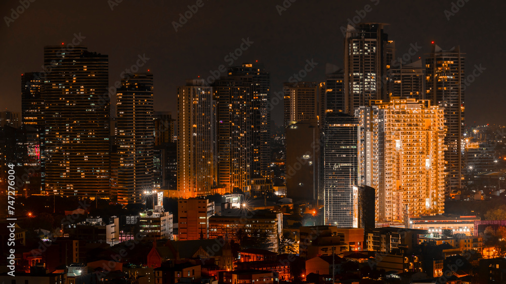 A vibrant night view of Rockwell, Makati's skyline with numerous illuminated skyscrapers and urban buildings.