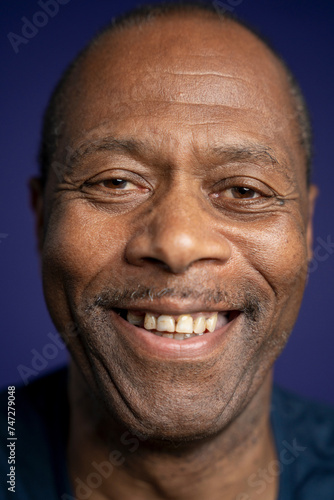 Portrait of smiling man against purple background