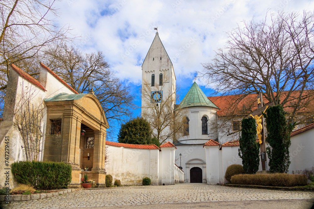 The monastery church of St Peter and Paul in the Benedictine Abbey of Thierhaupten in Bavaria on a spring day with a blue sky and changing cloud cover