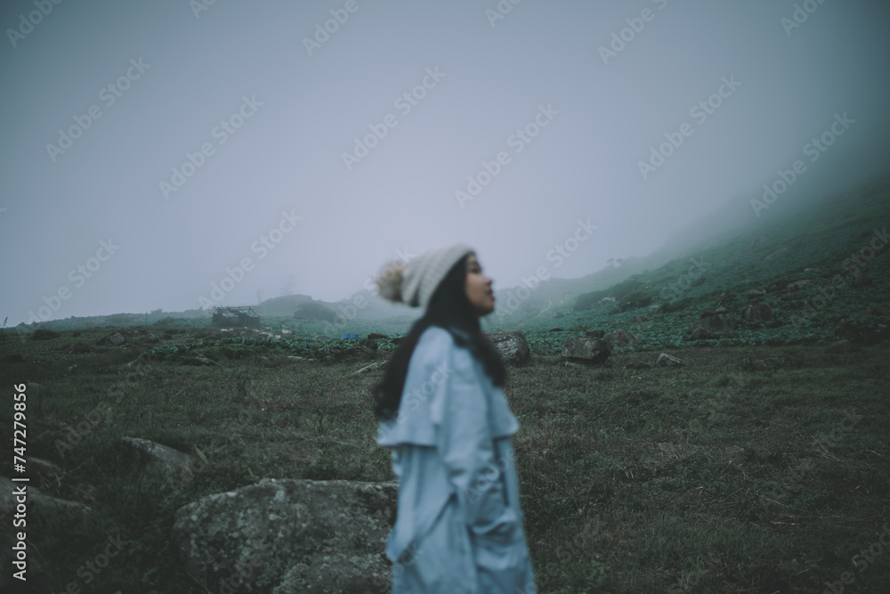 Woman in a sweater looking at the fog