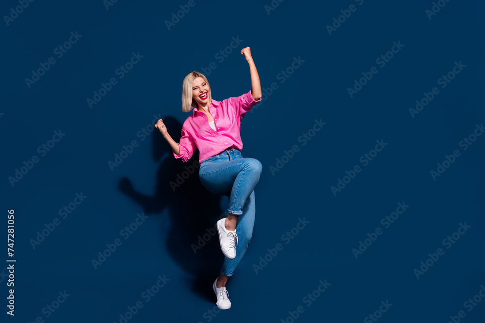 Full length photo of overjoyed woman wear stylish shirt raising up fists scream yeah win gambling isolated on dark blue color background