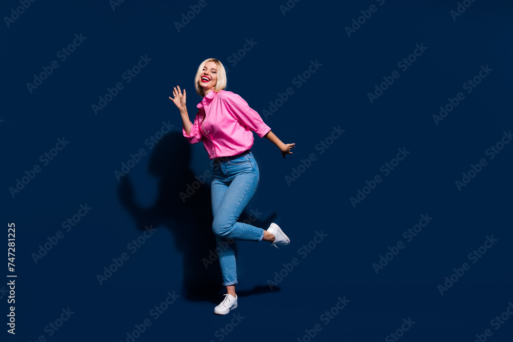 Full body photo of eccentric woman wear stylish shirt denim trousers celebrate season sale dancing isolated on dark blue color background Full body photo of eccentric woman wear stylish shirt denim trousers celebrate season sale dancing isolated on dark blue color background