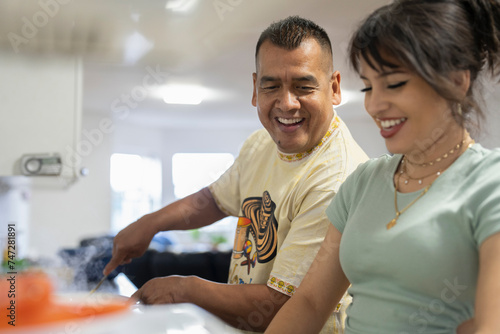 Members of family preparing food in kitchen