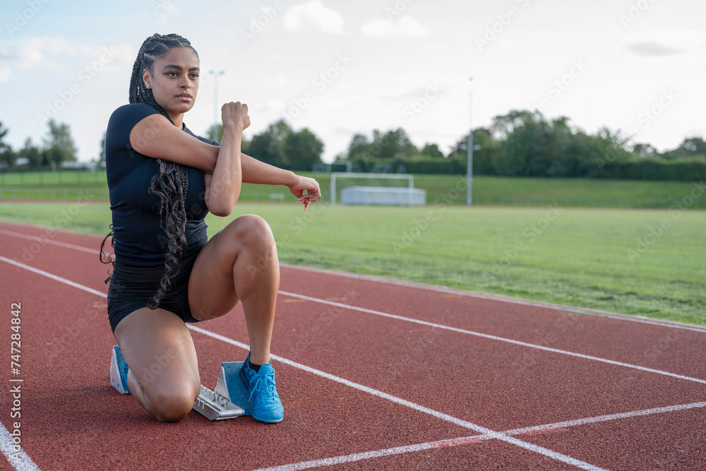Female athlete stretching before run at stadium