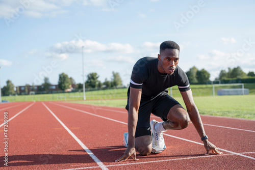Athlete preparing to sprint at running track