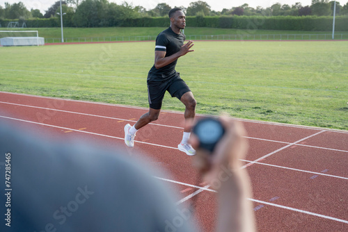 Athlete sprinting at running track photo