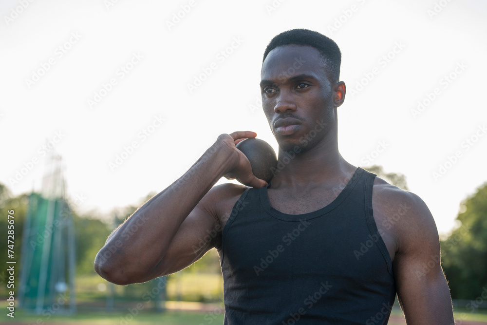 Naklejka premium Portrait of athlete holding shot put