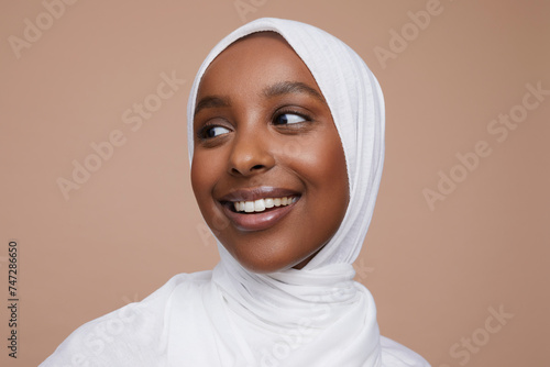 Studio shot of smiling young woman wearing white hijab photo