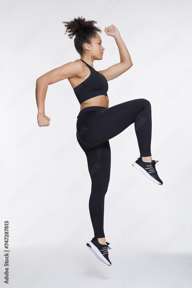 Obraz premium Studio shot of athletic woman in spots clothing exercising