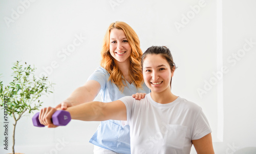 Modern rehabilitation physiotherapy at work with client holding dumbell