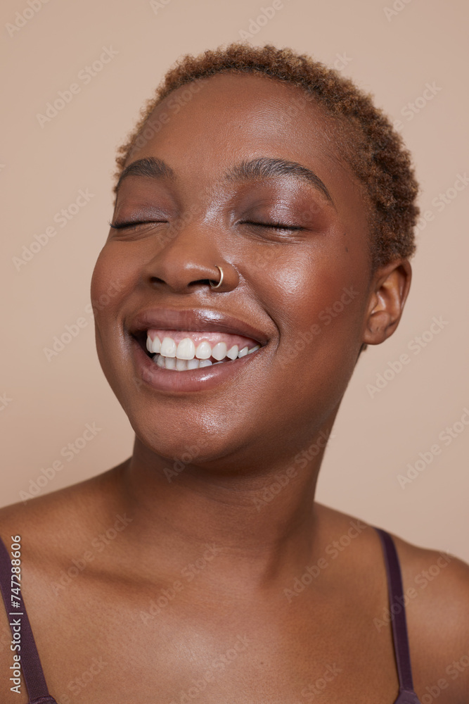 Studio portrait of smiling woman with nose ring and eyes closed Studio portrait of smiling woman with nose ring and eyes closed