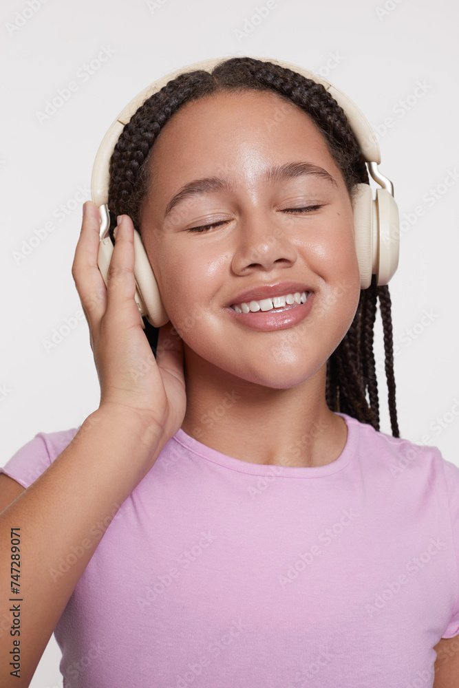 Studio portrait of smiling girl with headphones and eyes closed Studio portrait of smiling girl with headphones and eyes closed