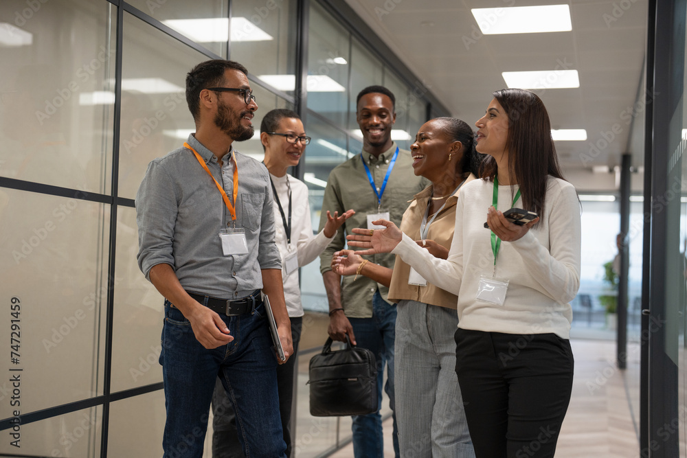 Group of office workers walking together in office corridor