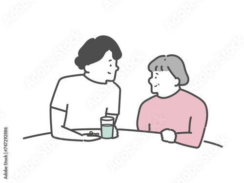 高齢女性の服薬介助を行う女性介護士