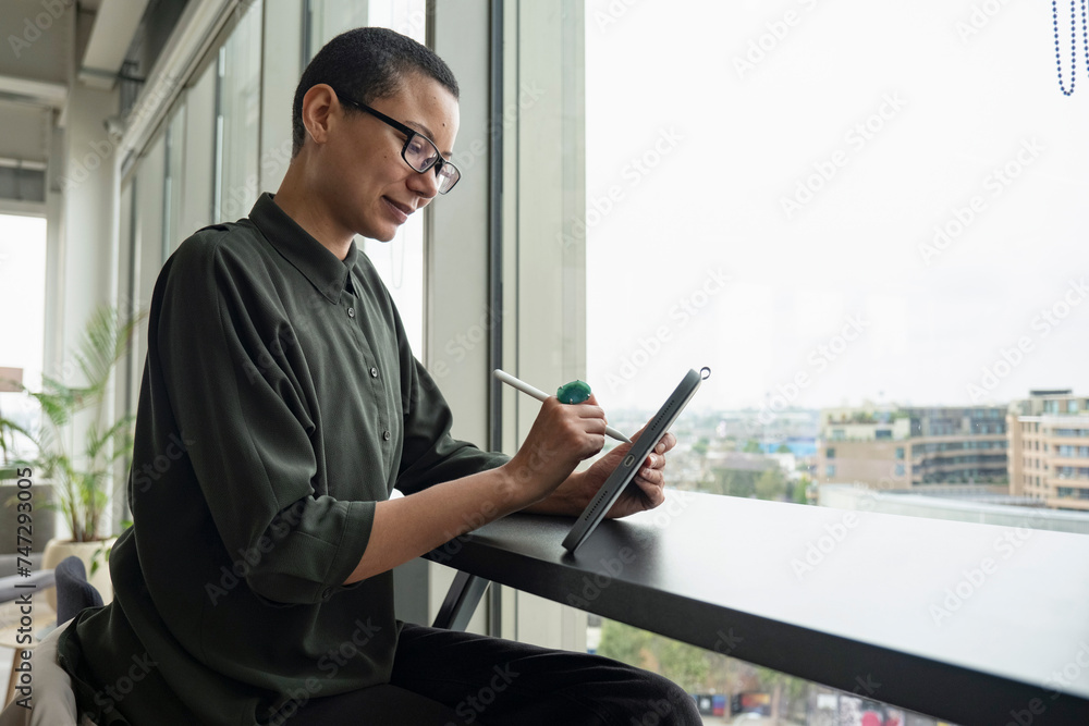 © Cultura Creative - Woman using digital tablet in office