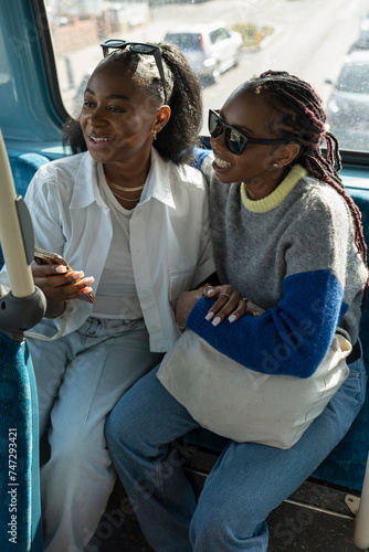 Young female couple riding city bus