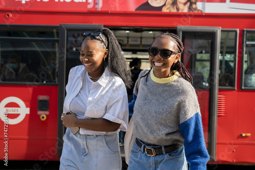 Smiling young women getting off city bus