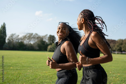 Young female friends jogging in park