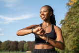 Smiling young woman checking time after jogging