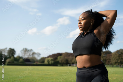 Young woman stretching in park photo