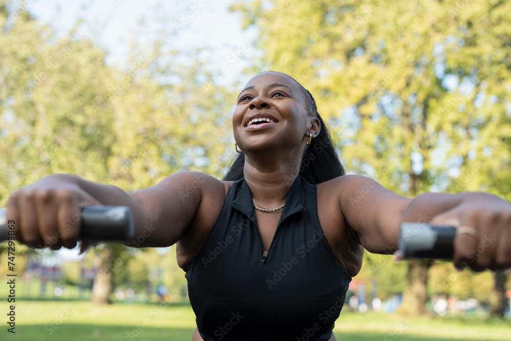 Smiling young woman exercising in outdoor gym Smiling young woman exercising in outdoor gym