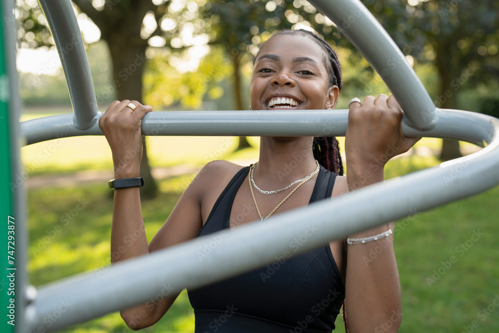 Smiling young woman exercising in outdoor gym
