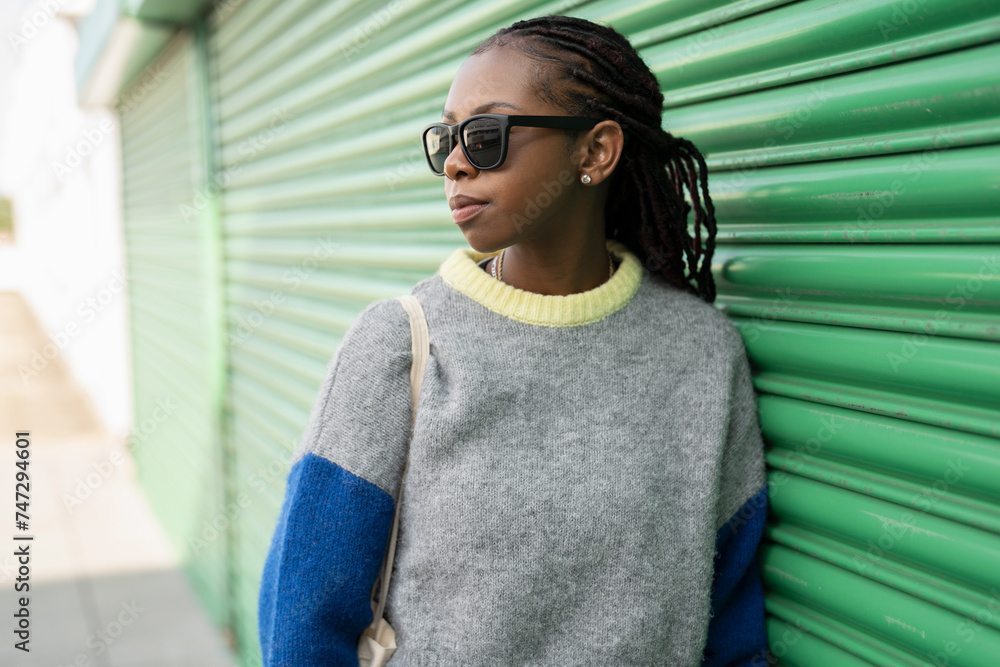 Young stylish woman leaning against green door Young stylish woman leaning against green door