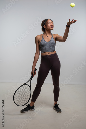 Woman holding tennis racket and throwing tennis ball © Cultura Creative