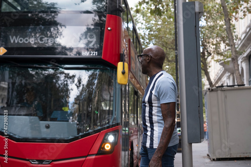 Tableau sur toile UK, London, Mature man posing next to double decker bus