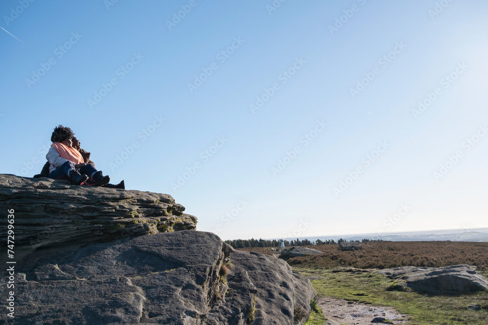 Two women looking at landscape from top of rock