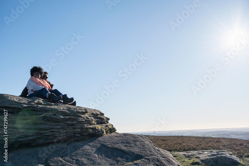 Two women looking at landscape from top of rock