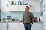 Smiling mature man standing in kitchen at home