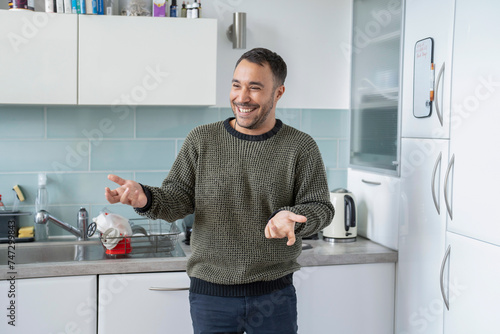 Smiling mature man standing in kitchen at home