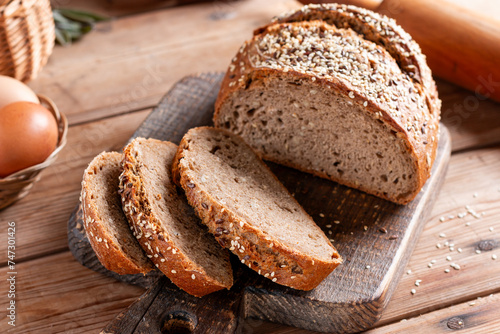 Protein bread (without flour) with linseeds, sunflower seeds and sesame seeds on cutting board. Selective focus.