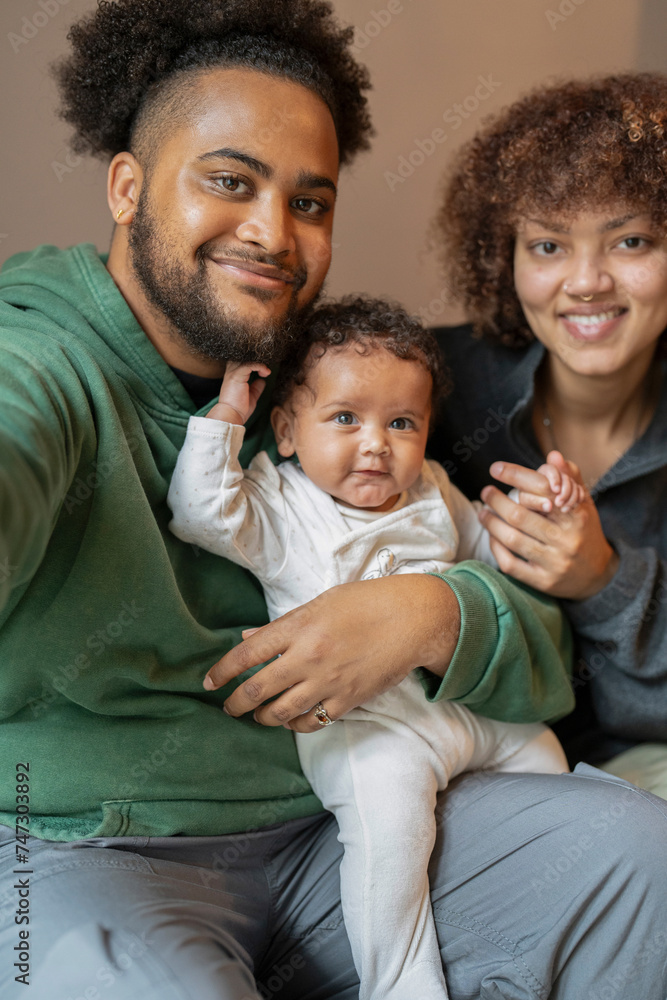 Smiling parents with baby daughter at home Smiling parents with baby daughter at home