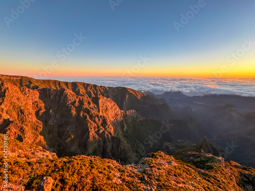 Panoramic view of majestic mountain ridges at sunrise seen from top of Pico do Areeiro, Madeira island, Portugal, Europe. First sunlight touching unique rock formations. Idyllic hiking trail at dawn