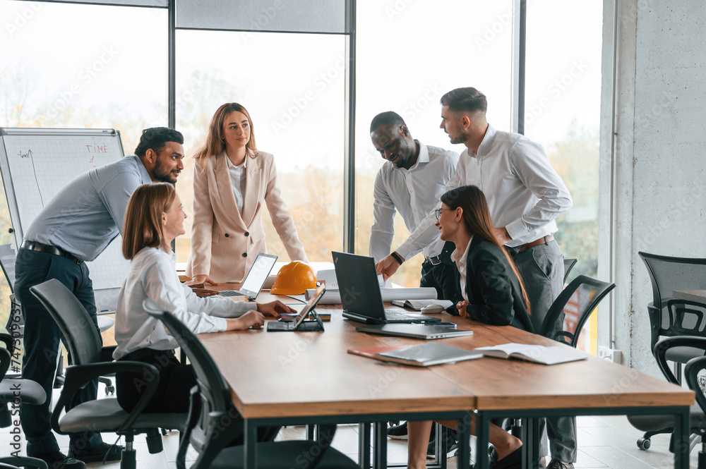 © standret - On the meeting, discussing the plans. Group of office workers are together indoors